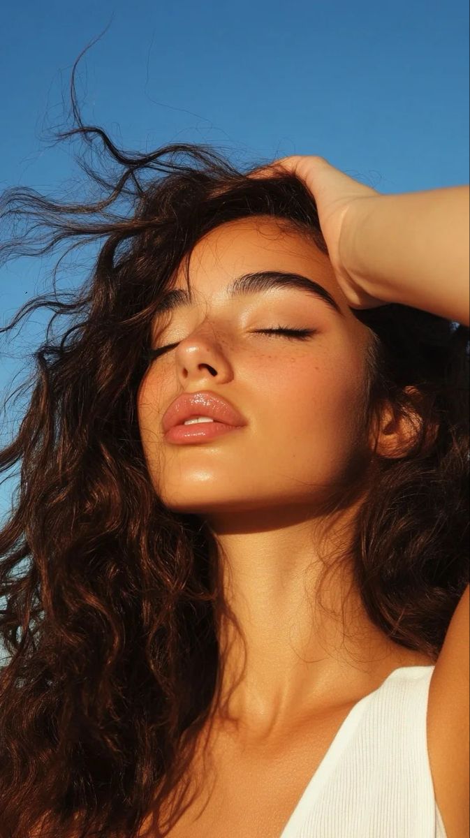 Woman with eyes closed in warm sunlight feeling calm