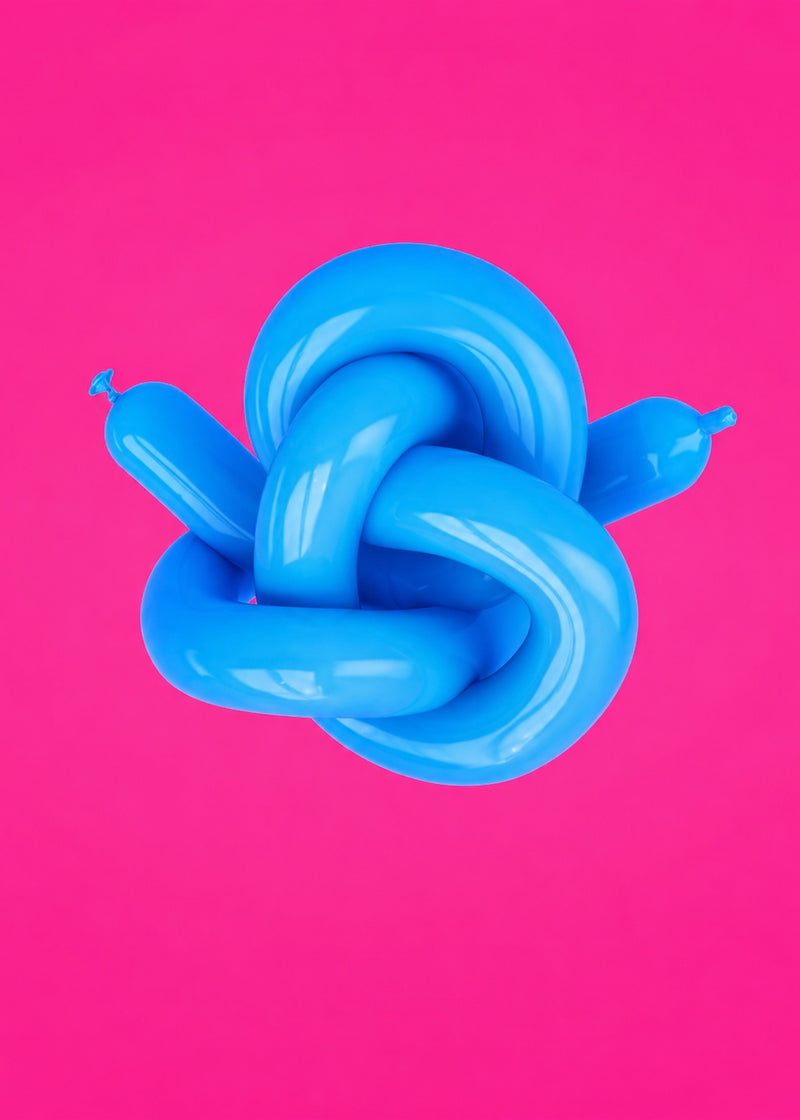 Blue balloon tied in intricate knot on pink background